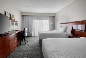 a hotel room with two beds and a flat screen tv at Courtyard by Marriott Lincroft Red Bank in Red Bank +26 photos