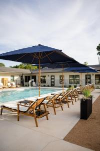 a group of picnic tables with an umbrella next to a pool at Gloria Inn - Unit 8 in Waco