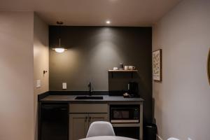 a kitchen with a sink and a black wall at Gloria Inn - Unit 8 in Waco +2 photos