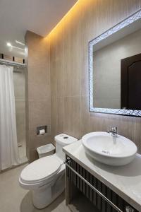 a bathroom with a sink and a toilet and a mirror at Hotel Madrigal in Portoviejo +46 photos