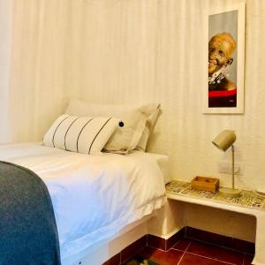 a bedroom with a bed and a table with a lamp at LAS DUNAS Caves - Olivo in Benamaurel