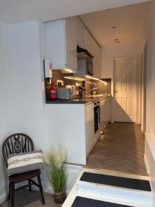 a kitchen with white cabinets and a chair in a room at The Glebe in Fort William