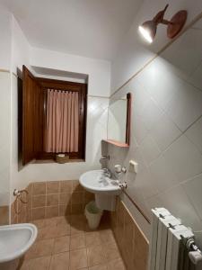 a bathroom with a sink and a toilet and a mirror at Casa Cuoco in Civita Campomarano