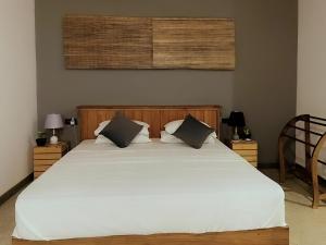 a bedroom with a large white bed with two pillows at Turtle Moon Lodge in Rekawa