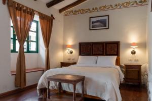 a bedroom with a large bed with a wooden headboard at Hospedaje La Florida in Urubamba