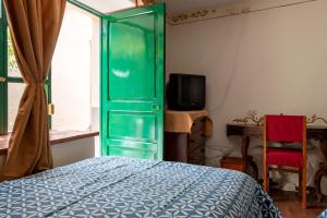a green door in a bedroom with a bed and a tv at Hospedaje La Florida in Urubamba