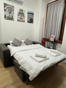 a bedroom with a large bed with white sheets at App Borsa Trieste in Trieste