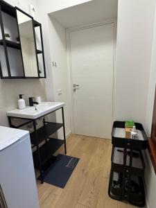 a bathroom with a sink and a white door at App Borsa Trieste in Trieste +8 photos