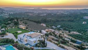 an aerial view of a mansion with a sunset at Villa Kedria with a panoramic ocean view in Souda