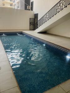 a swimming pool with blue water and a staircase at Exotic Two bedroom apartment in Abuja