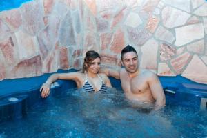 a man and a woman sitting in a hot tub at Hotel Don Carlo in San Marco Argentano