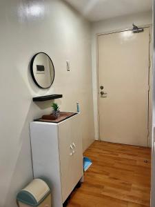 a bathroom with a vanity and a mirror and a door at Marrione's Pad in Davao City