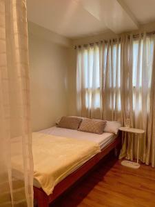 a bed in a room with a window with curtains at Marrione's Pad in Davao City