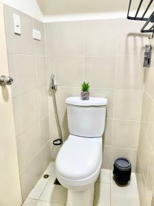 a bathroom with a toilet with a plant on it at Marrione's Pad in Davao City