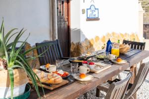 a wooden table with food and bread on it at LAS DUNAS Caves - Olivo in Benamaurel