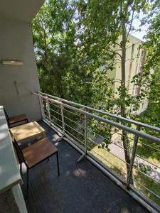 a balcony with a desk and a chair on a building at Városközpont Tata in Tata