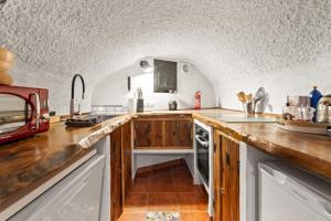 a kitchen with wooden counter tops and a sink at LAS DUNAS Caves - Olivo in Benamaurel +19 photos