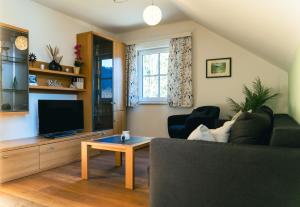a living room with a couch and a tv at Ferienwohnung Kahlseneck in Fischerndorf