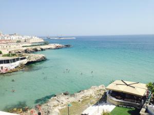 a group of people in the water at a beach at B&B Portorosso in Monopoli