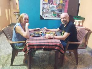 a man and a woman sitting at a table at Namitha guest house in Hampi
