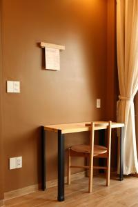 a wooden table and a chair next to a wall at Hale Homestay in Ấp Thanh Sơn (1) +44 photos