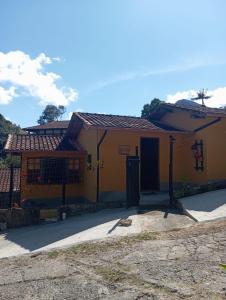 a yellow building with a gate in front of it at Chalé da Lili in Nova Friburgo