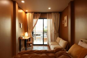 a bedroom with a bed and a couch and a window at Hale Homestay in Ấp Thanh Sơn (1)