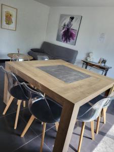 a wooden table with chairs in a living room at Maison Mimosa in Saumur
