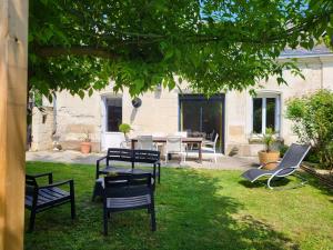 a group of chairs and a table in a yard at Maison Mimosa in Saumur