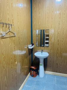 a bathroom with a white sink and wooden walls at Farm Tân Tiến in Ấp Bình Thạnh