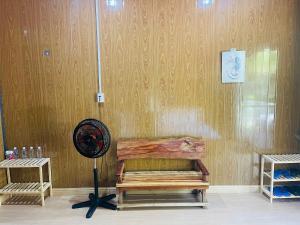 a room with a fan and a wooden wall at Farm Tân Tiến in Ấp Bình Thạnh