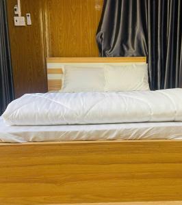 a bed with white sheets and pillows on it at Farm Tân Tiến in Ấp Bình Thạnh