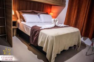 a bedroom with a bed and a table with towels on it at CONFORTO IMBATIVEL - 25 metros do MAR - 2 Quartos com AR CONDICIONADOS SPLIT, Air Fryer, WI-FI, Disney Plus, Star Plus, HBO Max, Cadeiras de Praia e Caixa Térmica - 8 pessoas com Muito Conforto - Melhor Localização! in Guarapari
