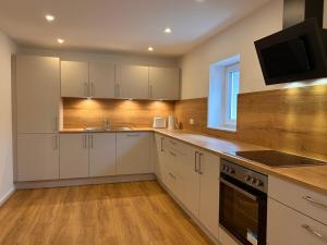 a kitchen with white cabinets and a tv on the wall at Groß Höpper in Albertshofen