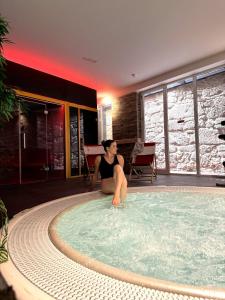 a woman is sitting in a swimming pool at Smartr Porto Gaia & Spa in Vila Nova de Gaia