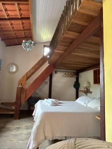 a bedroom with a bed and a staircase in a room at Casinha da Mila in Piatã