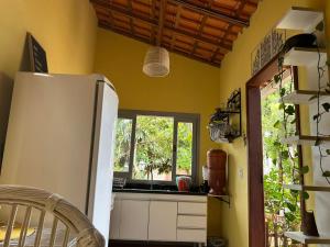 a kitchen with a white refrigerator and a window at Casinha da Mila in Piatã