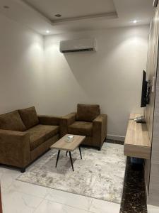 a living room with two couches and a coffee table at جميرا محايل in Muhayil