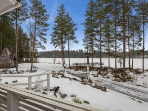 a porch with snow and trees and a house at Holiday Home Kalaranta by Interhome in Lihavanpää