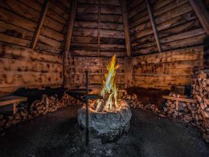 a fire pit in a room with logs at Holiday Home Kalaranta by Interhome in Lihavanpää
