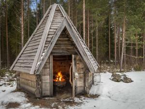 a log cabin with a fire in the snow at Holiday Home Kalaranta by Interhome in Lihavanpää