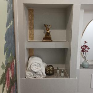 a shelf with towels and a statue in a room at Suite Zen Balnéo in Montpellier