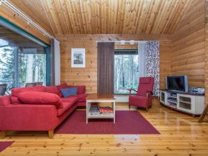 a living room with a red couch and a tv at Holiday Home Villa populus by Interhome in Pertunmaa +16 photos