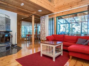 a living room with a red couch and a fireplace at Holiday Home Villa populus by Interhome in Pertunmaa