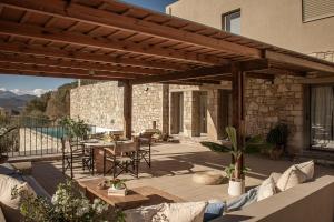 a patio with a wooden pergola and a table at Istron Luxury Villas in Istro
