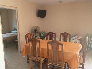 a dining room table with chairs and a television on the wall at Vista del Lago in Villa Carlos Paz