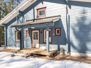 a blue house with a porch in the snow at Holiday Home Klippan by Interhome in Tuuhonen