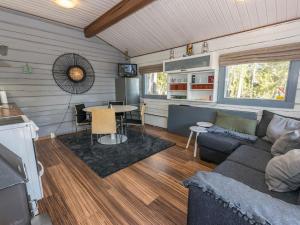 a living room with a couch and a table at Holiday Home Jarsala by Interhome in Töfsala