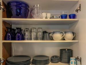a pantry filled with lots of glass jars and plates at Holiday Home Jarsala by Interhome in Töfsala +21 photos