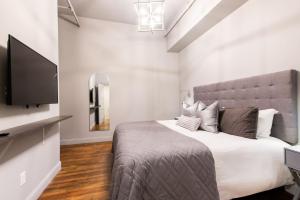 a bedroom with a bed and a flat screen tv at Hollyhock Suite 403 in Louisville